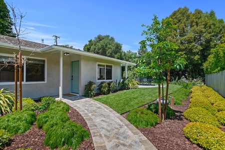 A charming single-story home with beautifully landscaped gardens and mature trees creating a peaceful setting for your getaway.