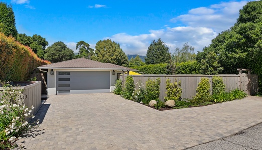 Modern single-story home with landscaped gardens and mountain backdrop in peaceful residential setting.