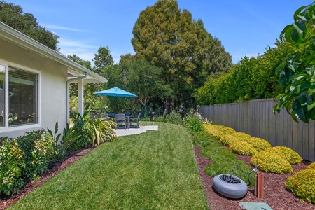 Step into your private backyard oasis with lush landscaping, perfect lawn for relaxation, and outdoor dining under mature trees.