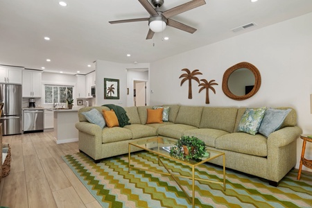 Relax in your bright, open-concept living space with cozy sectional seating and tropical-inspired touches.
