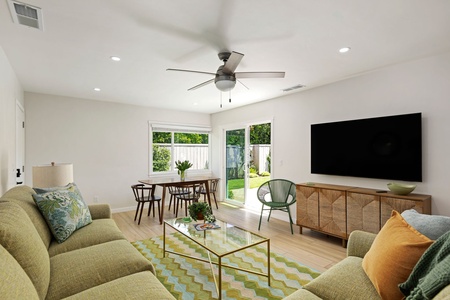 Relax in your bright, modern living space with stylish furnishings and garden views through expansive windows.