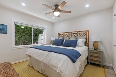 Drift off to sleep in this serene bedroom with crisp linens and gentle ceiling fan breeze.