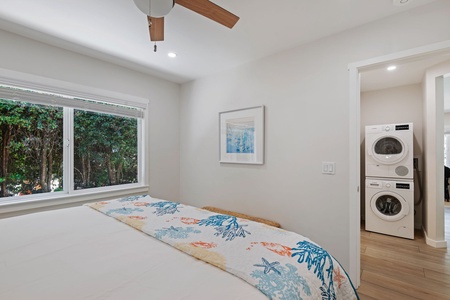 Your bright bedroom features a ceiling fan and convenient laundry access, with a peaceful garden view.
