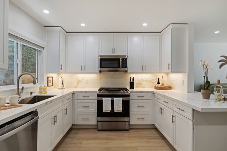 Your modern culinary haven features sleek quartz countertops, premium stainless steel appliances, and thoughtful lighting that makes cooking a joy.