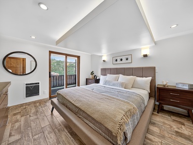 Primary bedroom with walk out balcony, king size bed and smart tv