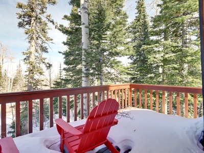 Second-floor balcony with comfortable seating and serene views of the surrounding trees.