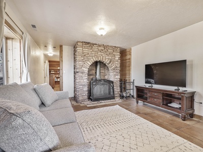 Basement suite with wood burning fireplace, sleeper sofa and 56" Smart TV