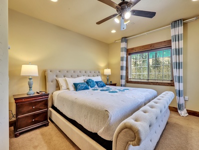 View of Primary Bedroom with King Size Upholstered Bed, Ceiling Fan, Night Stands with Table Lamps