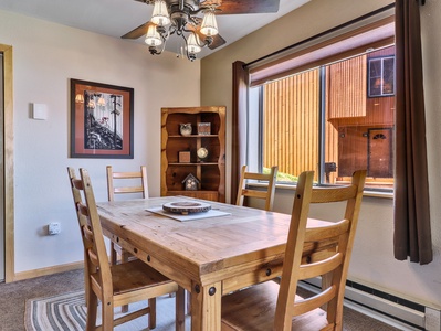 View of the dining room with seating for 4, ceiling fan, and cupboard