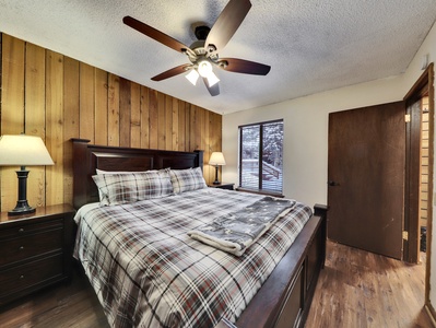 Primary bedroom featuring a king-size bed, nightstands, and a ceiling fan for added comfort