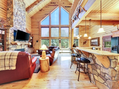 View of Main Living Area, with Expansive Floor to Ceiling Windows and Stone Kitchen Island