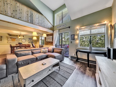 View of Living Room Sofa, smart TV, blue ray video player, vaulted ceiling, fireplace, floor lamps, entertainment console, coffee table