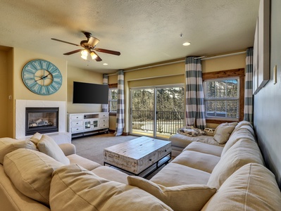 View of Living Room with Ceiling Fan, Smart TV with Roku, Gas Fire Place, Sectional Sofa, Coffee Table, Access to Private Balcony