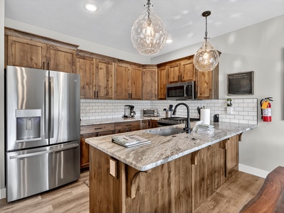 Fully stocked kitchen with sleek stainless steel appliances, custom cabinetry, and beautiful countertops—perfect for preparing meals and gathering together