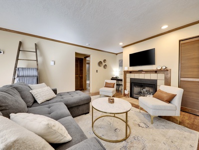 View of living room with comfortable seating, gas fire place, plush blankets and 48" LG smart TV