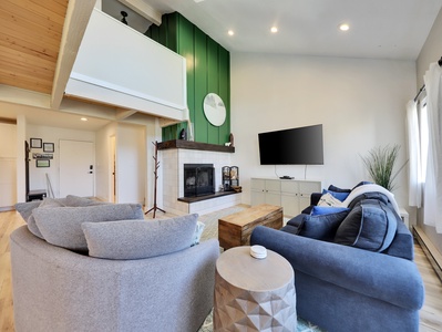 Bright and spacious living room, newly remodeled, featuring a cozy wood-burning fireplace