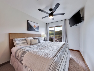 View of Primary Bedroom, King size Bed, Private Connected Walk-Out Balcony Ceiling Fan and 36" HDTV with Roku