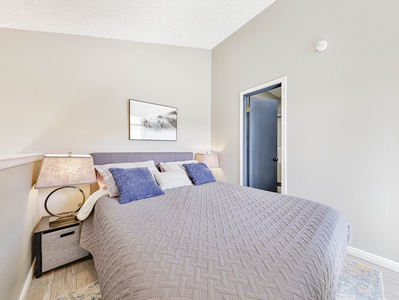 View of loft bedroom with queen size bed and attached bathroom