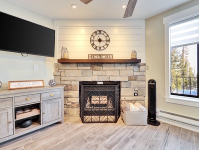 View of upgraded Living Room with Wood Burning Fire Place, Media Console, and 65" Flat Screen TV