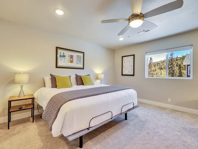 View of Primary Bedroom with King Size Bed, Nightstands, Ceiling Fan and 56" Smart TV