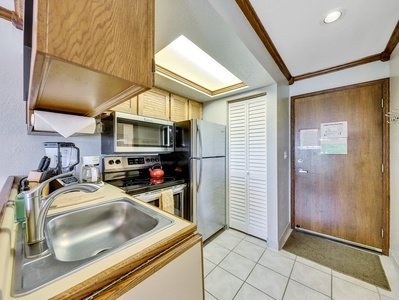 Kitchen view, stainless steel sink, microwave, stove/oven, refrigerator & coffee machine