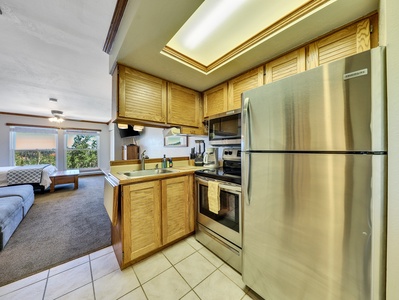 Kitchen view, stainless steel sink, microwave, stove/oven, refrigerator & coffee machine