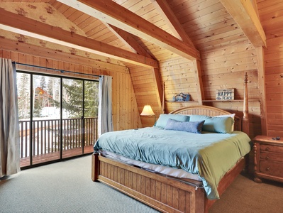 View of the primary bedroom featuring a king size bed and walk out balcony and 55" Smart TV