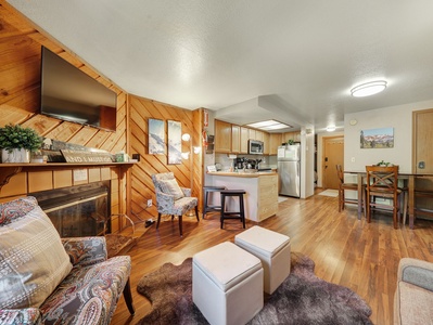 Cozy living room with a wood-burning fireplace, smart TV, pull-out sofa, and access to the private balcony