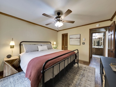 View of the primary bedroom featuring a plush and comfortable king-size bed, ceiling fan, and 48" LG smart TV.