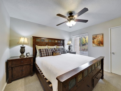 View of primary bedroom with king size bed, plush bedding and extra blankets and 42" flat screen TV