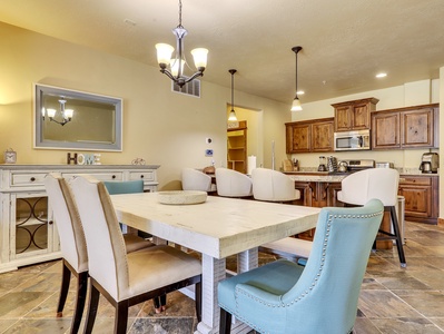 View of Dining Room with Dining Table & Chairs, Buffet Table, Chandelier, Pendant Lights, Kitchen Island with Seating for 4