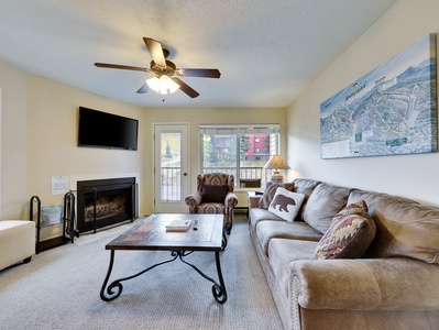 View of living room with comfortable sofa bed, 42" smart TV and wood burning fireplace