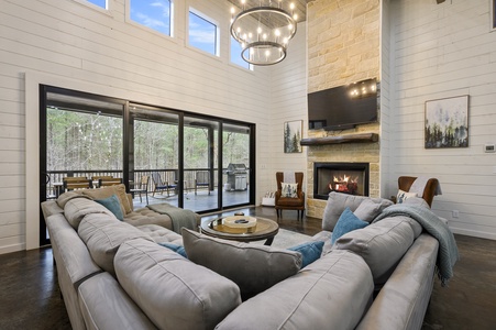 A beautiful and comfortable living room with sectional, 65" TV, and gas fireplace.