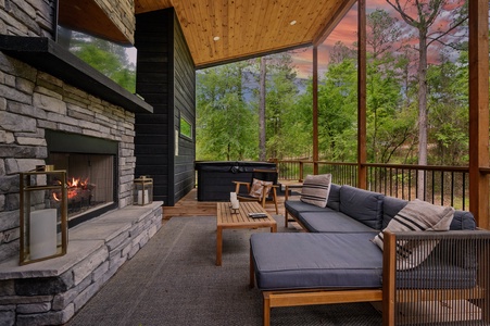 The back patio sits elevated high above the ground, and features a private hot tub, outdoor fireplace with smart TV, and a propane grill.