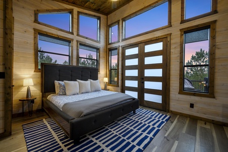 Upstairs bedroom with doors leading out to rooftop deck.