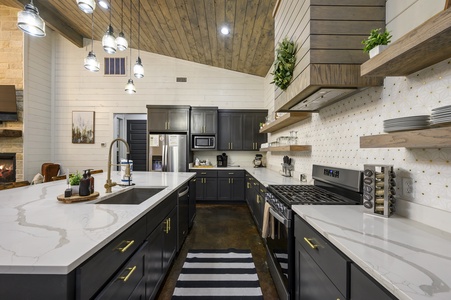 This modern kitchen includes a rerfrigerator, oven/stove, Microwave, dishwasher, and Keurig coffee maker.