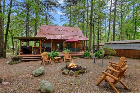 The ultimate cabin experience with a wooded surrounding, fire pit and bar and grill area by the hot tub!