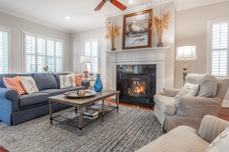 Cozy seating with sofa, two chairs and a fire place.