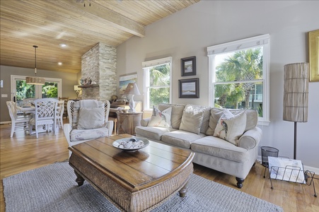 Living Room coffee table and sofa with sun shining through windows.