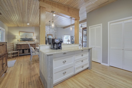 Kitchen island with view of dining area. Wood ceilings and floors.