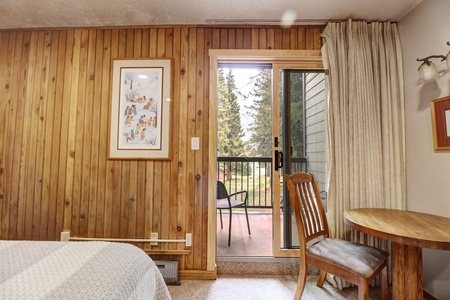 Looking over to a desk and chair and a private balcony.