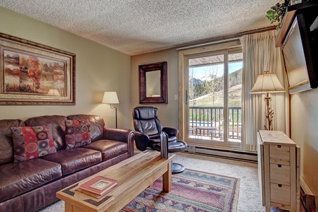 Cozy living room with access to a private balcony which offers great views of East Village ski slopes.