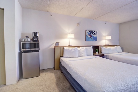 The hotel room features a mini fridge, microwave, and coffee maker.