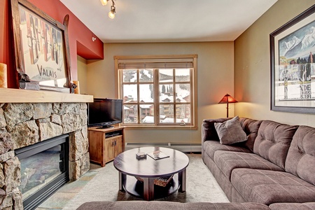 Cozy living room with large windows and fireplace.