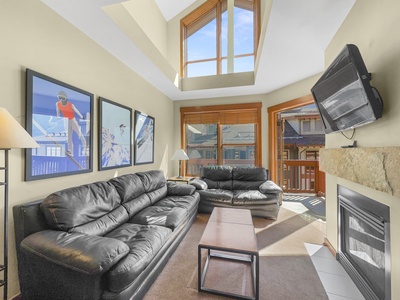 The living room features a queen sleeper sofa couch and large vaulted ceilings.