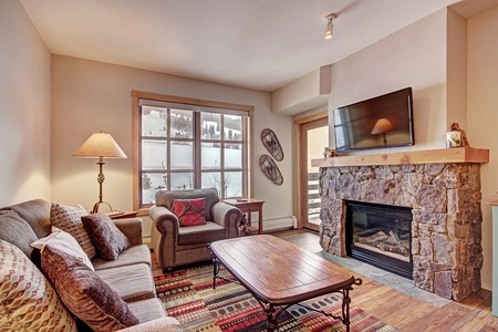 Cozy living room area with fireplace, patio, and lots of natural light.