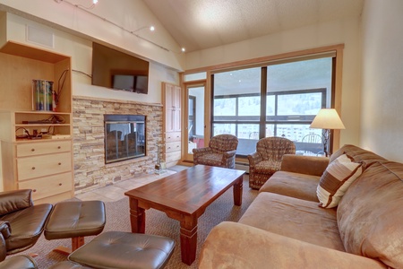 Living room features large windows for a lot of natural light and a wood burning fireplace.