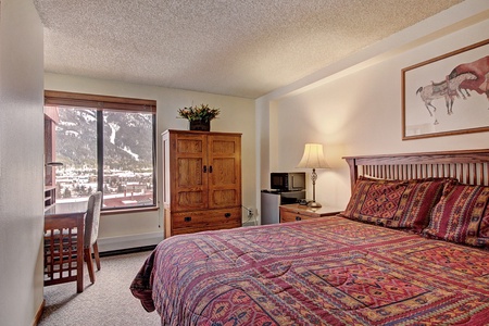 Cozy hotel room features a king bed