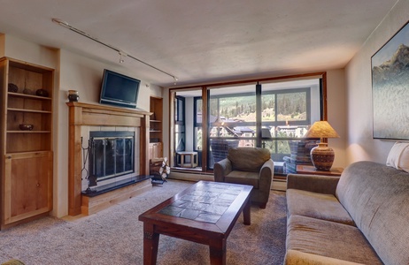 A cozy living room with TV and fireplace.