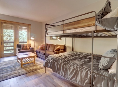 Hotel room featuring a queen sleeper sofa and double sized bunk beds.